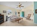 Bright living room featuring arched windows, ceiling fan, and neutral carpet, creating a cozy atmosphere at 4461 La France Ave, North Port, FL 34286