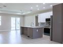 Modern kitchen featuring stainless steel appliances, a large island, and sleek cabinetry at 4880 Cornsilk Ter, North Port, FL 34286