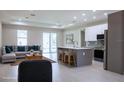 Open-concept living room and kitchen with modern finishes and plenty of natural light at 4880 Cornsilk Ter, North Port, FL 34286