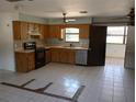 Spacious kitchen featuring classic appliances and tiled floors, ready for a personal touch and updates at 7321 Bolten Ln, Port Charlotte, FL 33981