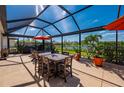 Spacious screened patio features a dining table, outdoor furniture, and a backyard view, perfect for entertaining at 7501 Mikasa Dr, Punta Gorda, FL 33950