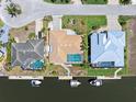Aerial view of waterfront home with a screened pool, boat dock, canal access, and well-maintained landscaping at 931 Cimarron Dr, Punta Gorda, FL 33950