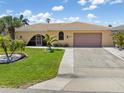 Charming single-story home with a tile roof, arched entry, a well manicured lawn and driveway at 931 Cimarron Dr, Punta Gorda, FL 33950