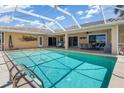 Screened pool with tile trim, an outdoor bar, seating, and views of the backyard at 931 Cimarron Dr, Punta Gorda, FL 33950