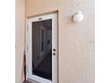 A close up of the front door with a screen, light fixture, and umbrella to the side at 9850 Fiddlers Green Cir # 130, Rotonda West, FL 33947