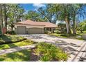 Beautiful home featuring a circular driveway, a well-maintained lawn, and mature trees providing ample shade at 1102 Hunt Club Ln, Valrico, FL 33594