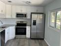 A modern kitchen featuring stainless appliances, granite countertops and white cabinetry at 1258 Barbara Dr # 202, Venice, FL 34285