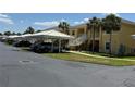View of the condominium exterior with parking under white canopies and stairs to the second floor units at 1295 Saxony Cir # 2101, Punta Gorda, FL 33983