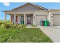 Charming home featuring a welcoming porch, red door, and a convenient two-car garage at 15345 Pottstown Ave, Port Charlotte, FL 33981