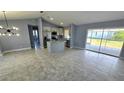 Open-concept interior featuring a kitchen with stainless steel appliances, an island, and a seamless flow to the living area at 18519 Alphonse Cir, Port Charlotte, FL 33948