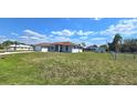 Spacious lawn surrounding a light gray home featuring a side shed and partial fencing for added privacy at 18519 Alphonse Cir, Port Charlotte, FL 33948