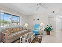Bright living room showcasing tile flooring, a comfortable sofa, and a large window offering neighborhood views at 19505 Quesada Ave # Pp201, Port Charlotte, FL 33948