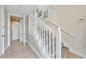 Bright staircase features carpeted steps, a white banister, and tiled floors at 196 Tarpon Cove Blvd # 722, Punta Gorda, FL 33950