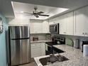 Updated kitchen with stainless steel appliances, granite countertops, and white cabinets at 21405 Olean Blvd # 531, Port Charlotte, FL 33952