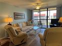 Bright living room featuring comfortable seating, a ceiling fan, and sliding glass doors to a balcony at 21405 Olean Blvd # 531, Port Charlotte, FL 33952
