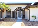 Inviting front entrance with arched doorway, decorative security door, and manicured landscaping at 25179 Campos Dr, Punta Gorda, FL 33983