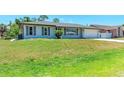 Inviting single-story home with a well-manicured lawn and gray shutters at 309 Aurora St, Port Charlotte, FL 33948