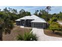 Elegant one-story home with a metal roof, attached garage, and landscaped front yard at 3136 Joshua St, Port Charlotte, FL 33948