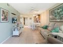 Inviting living room with neutral tones, tile flooring, a dining area, ceiling fan and kitchen in the background at 3221 White Ibis Ct # D2, Punta Gorda, FL 33950