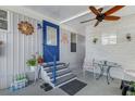 Inviting outdoor area with ceiling fan, furnishings, decor, and a welcoming blue front door at 3305 Blue Jay Ln, Englewood, FL 34224