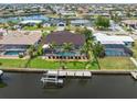 Aerial view of a waterfront home with a pool, private dock, boat lift, and tropical landscaping at 340 Belaire Ct, Punta Gorda, FL 33950
