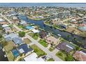 Aerial view of a waterfront community with palm trees, boat docks, swimming pools, and beautiful landscaping at 340 Belaire Ct, Punta Gorda, FL 33950