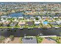 Gorgeous aerial view of a waterfront neighborhood and the canal featuring multiple homes, boat docks, and lush landscaping at 340 Belaire Ct, Punta Gorda, FL 33950