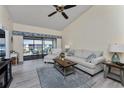 Bright living room with vaulted ceilings, fan, access to the screened patio and comfortable seating at 347 Coldeway Dr # G6, Punta Gorda, FL 33950
