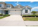 Townhome showcasing a two-car garage with a brick-paved driveway and meticulously maintained landscaping at 3664 Tin Cup Blvd, Sarasota, FL 34232