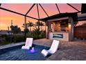 A screened-in pool with lounge chairs and outdoor kitchen is perfect for outdoor entertainment at 3729 Peace River Dr, Punta Gorda, FL 33983