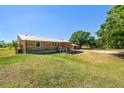 A log cabin-style home with a metal roof, complemented by a well-maintained lawn and mature trees at 47350 Bermont Rd, Punta Gorda, FL 33982