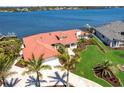 Expansive waterfront estate boasting meticulous landscaping, a private dock, and a sparkling pool, showcasing luxurious coastal living at 8115 Manasota Key Rd, Englewood, FL 34223