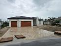 Stunning exterior view of a modern home with a two-car garage and brick paved driveway at 10522 Riverside Rd, Port Charlotte, FL 33981