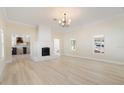 Bright, spacious living room with light wood floors, a white brick fireplace, and views into the kitchen at 110 Gilchrist St, Punta Gorda, FL 33950