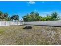 Fenced backyard featuring a simple fire pit and ample space for outdoor activities at 1210 Marlow St, Port Charlotte, FL 33952
