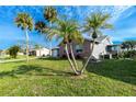 This lovely home has vibrant green yard with lush palm trees creating a tranquil setting at 13449 Muriel Ave, Port Charlotte, FL 33981