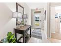 Welcoming entryway featuring neutral walls, tile floors, wood console table, and large decorative mirror at 1419 Powell Valley Dr, Port Charlotte, FL 33953