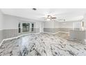 Spacious living room featuring large windows and a decorative ceiling fan at 1756 Elinor Pl, Englewood, FL 34223