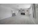 Bright living room open to the kitchen with gray tile floors, modern lighting, and electric fireplace at 20215 Macon Ln, Port Charlotte, FL 33952