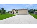 Charming single Gathering home with a wide driveway, neutral color palette, and a well-maintained lawn at 2186 Florala St, North Port, FL 34287