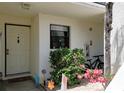 Inviting condo entrance featuring a well-lit entryway, a decorative door, and lovely landscaping with small garden at 2275 S Mccall Rd # 103, Englewood, FL 34224