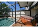 Relaxing screened patio with a hot tub, poolside access, and comfortable decking at 25188 Marion Ave # 10, Punta Gorda, FL 33950