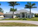 Attractive single-story home boasts a well-maintained lawn and mature palm trees at 27147 Guapore Dr, Punta Gorda, FL 33983