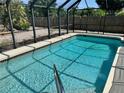 Sparkling pool with a screened enclosure offers a private backyard oasis at 376 Waterside St, Port Charlotte, FL 33954