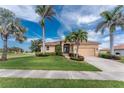 Charming single-story home featuring a lush green lawn, tropical landscaping, and a double-door entrance at 4015 La Costa Island Ct, Punta Gorda, FL 33950