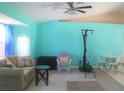 Bright living area featuring tiled floors, a ceiling fan, seating area and a separate area for a workout station at 4309 Badali Rd, North Port, FL 34286