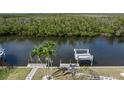 Beautiful backyard view showcasing a boat dock, canal, and mature palm trees at 5720 Almar Dr, Punta Gorda, FL 33950