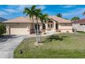 Charming single Gathering home featuring a well-manicured lawn, palm trees, and a two-car garage at 5720 Almar Dr, Punta Gorda, FL 33950