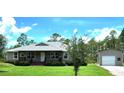 Cozy single-story home with charming covered porch and detached garage or shed, set on a generous lot at 6405 Alan Blvd, Punta Gorda, FL 33982