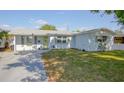 Charming single-story home with a light-blue painted exterior, neat landscaping, and a gray paved driveway at 8795 56Th N St, Pinellas Park, FL 33782